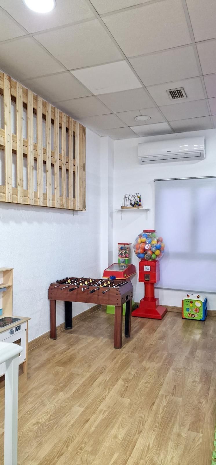 Una sala de juegos con una mesa de futbolín, una máquina expendedora de 