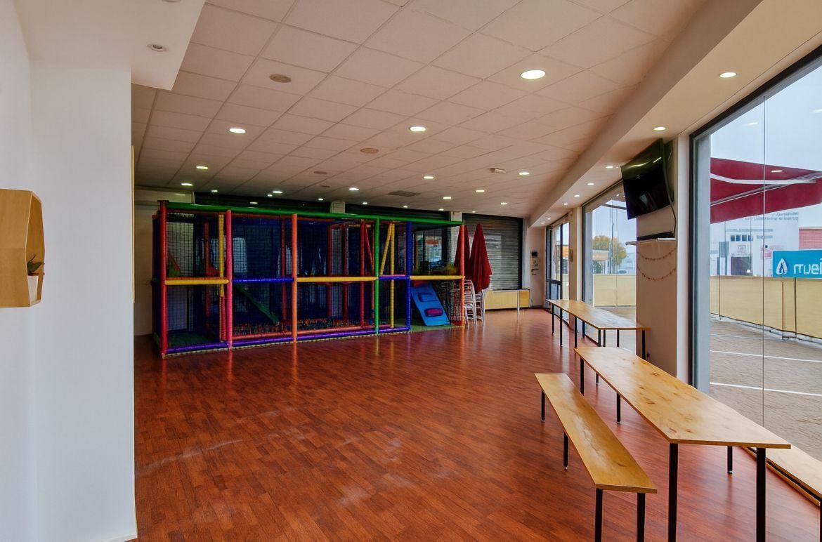 Zona de juegos interior con una colorida estructura para trepar, suelo con aspecto 