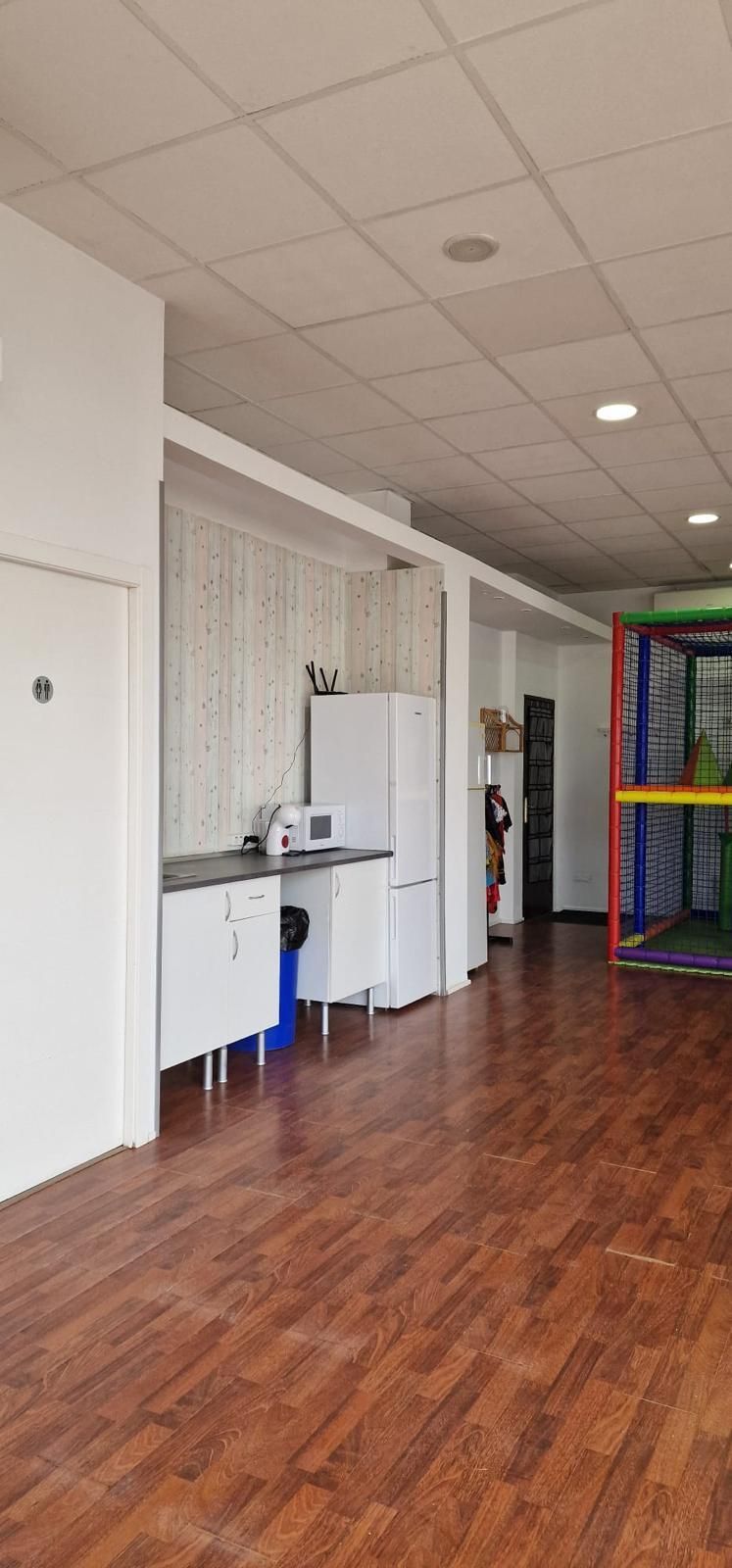 Un espacio interior luminoso con una zona de cocina equipada con armarios blancos