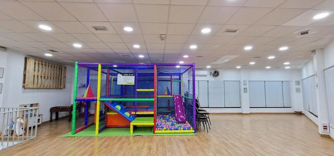 Un colorido parque infantil cubierto con estructura para trepar, tobogán