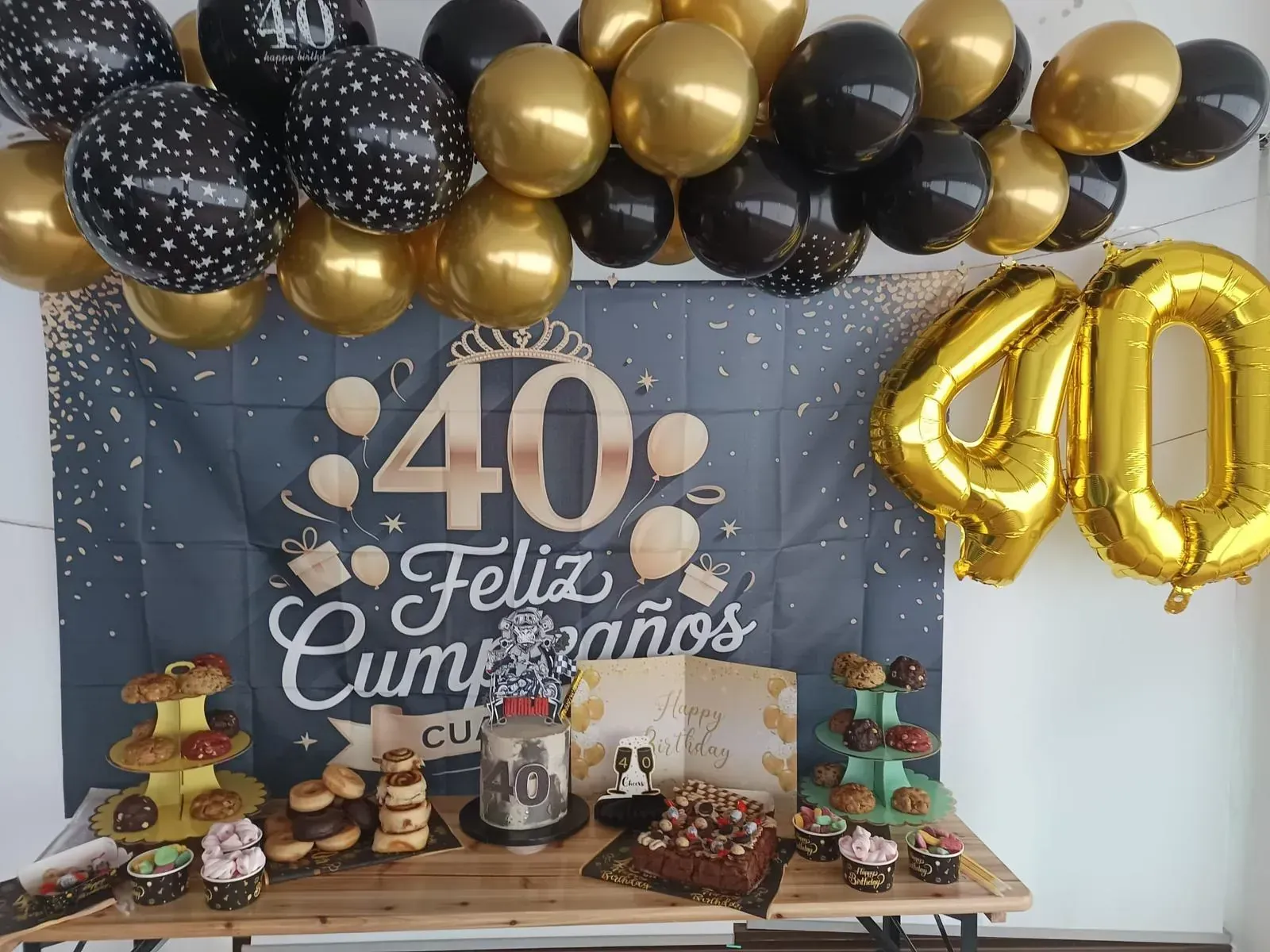 Una mesa festiva para celebrar un 40 cumpleaños con globos dorados 