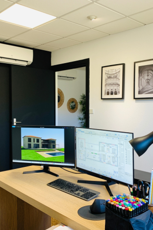 Un bureau avec deux écrans d'ordinateur et un clavier dessus.