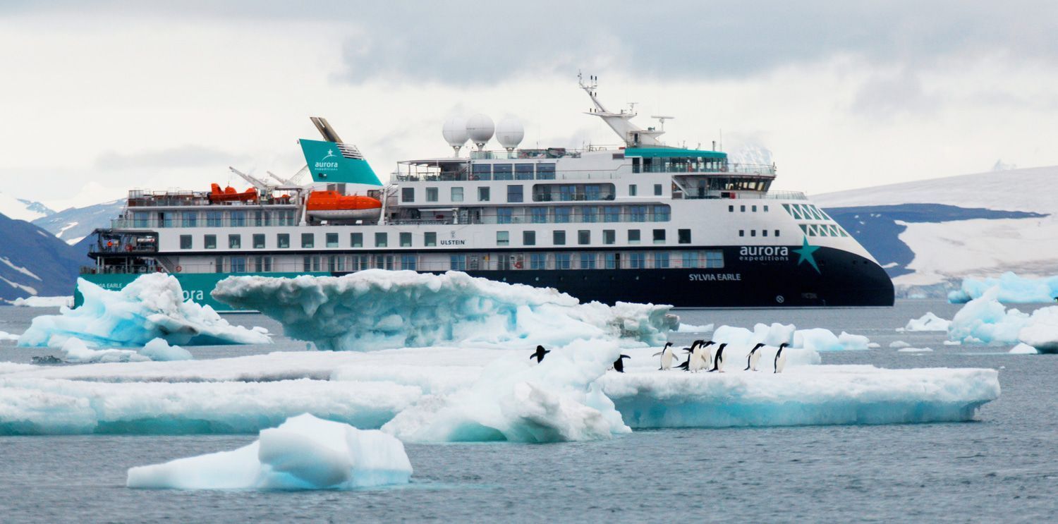 A large cruise ship is floating on top of a body of water surrounded by ice.