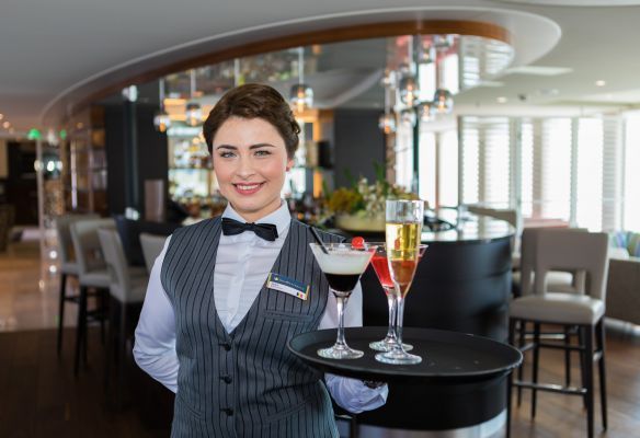 a waitress is holding a tray with two martini glasses on it on AmaKristina