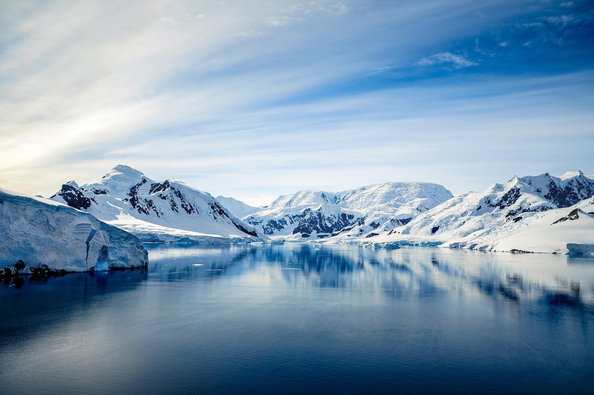 A large body of water surrounded by snow covered mountains in Antarctica