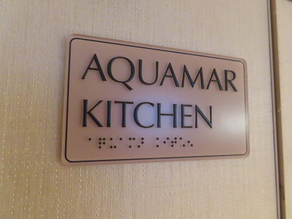 A sign on a door that says aquamar kitchen