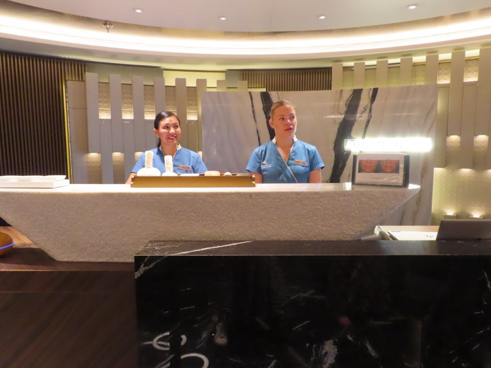 Two women are standing behind a counter in a hotel