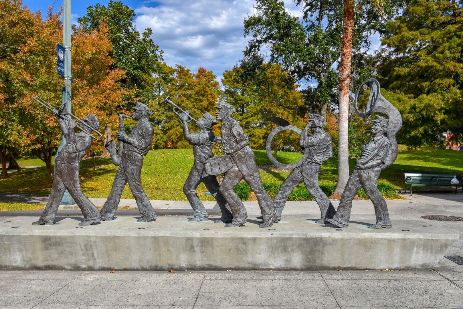 A statue of a group of people standing next to each other in a park.