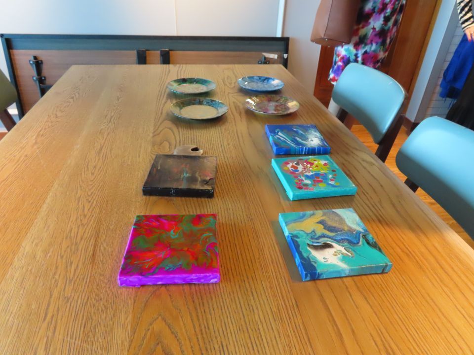 A wooden table with a row of small paintings on it