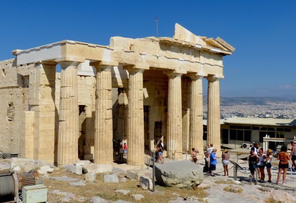 A group of people are standing in front of a building with columns at The Acropolis