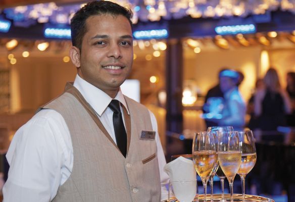 Attentive crew on Seven Seas Splendor - a waiter holding a tray of champagne