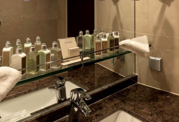 a bathroom with a sink , mirror , and bottles on a shelf on board Avalon Envision