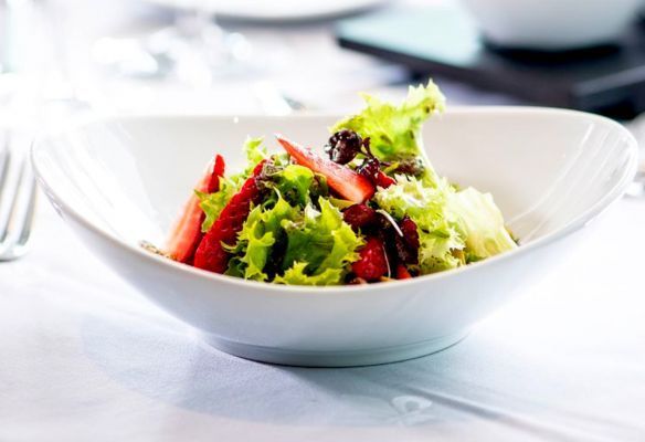 a white bowl filled with a salad on a table at Avalon Fresh on board Avalon Envision