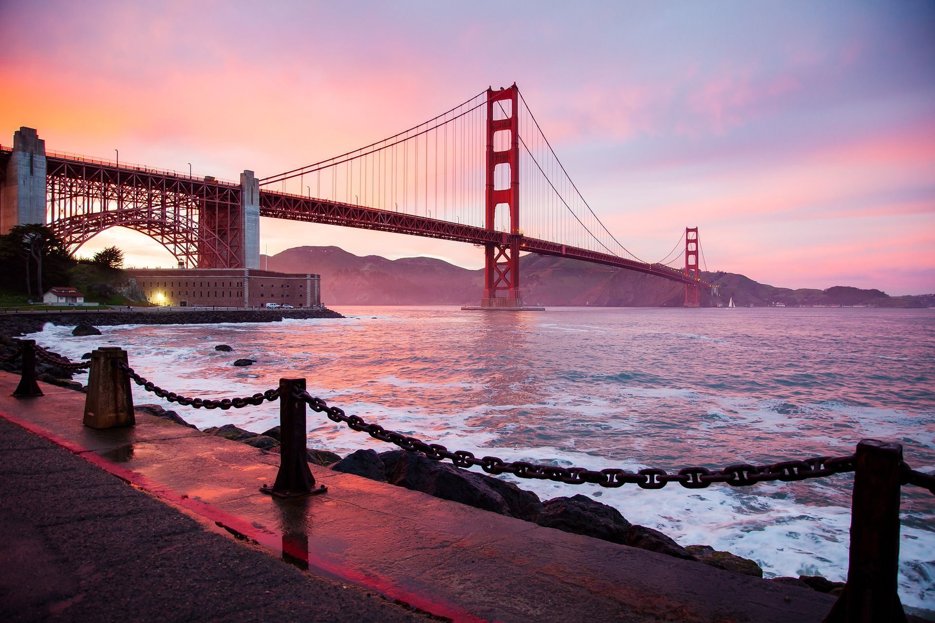 A bridge over a body of water with a sunset in the background