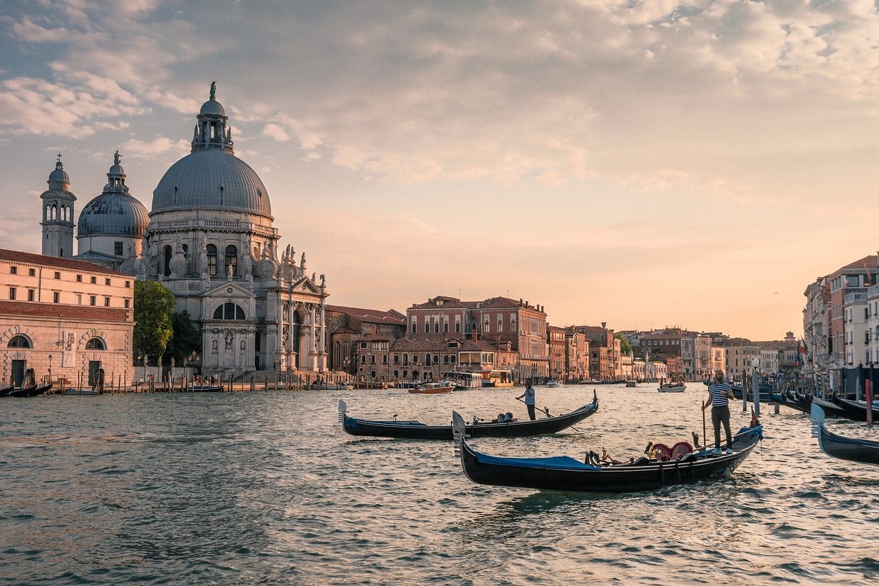 There are many gondolas in the water in venice.