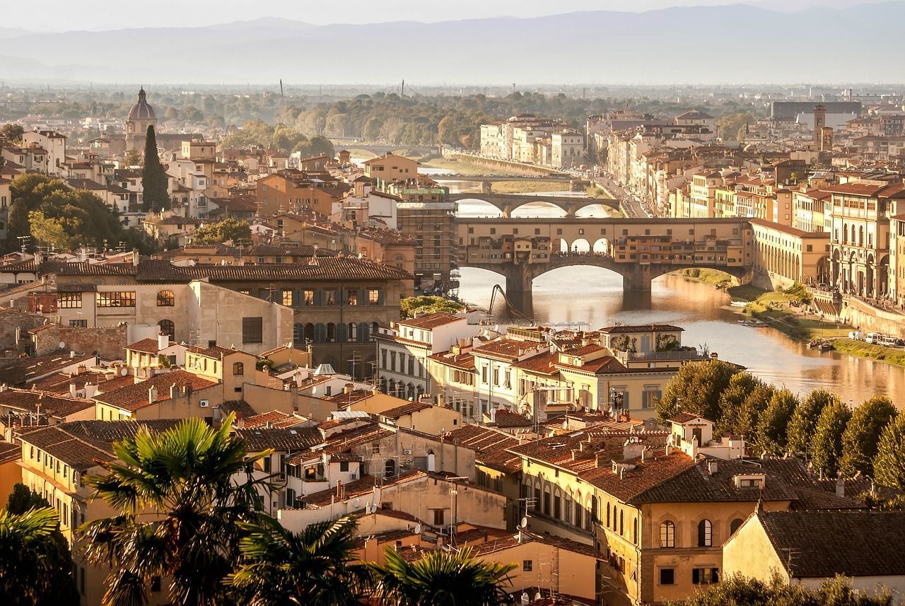 An aerial view of a city with a bridge over a river in Florence