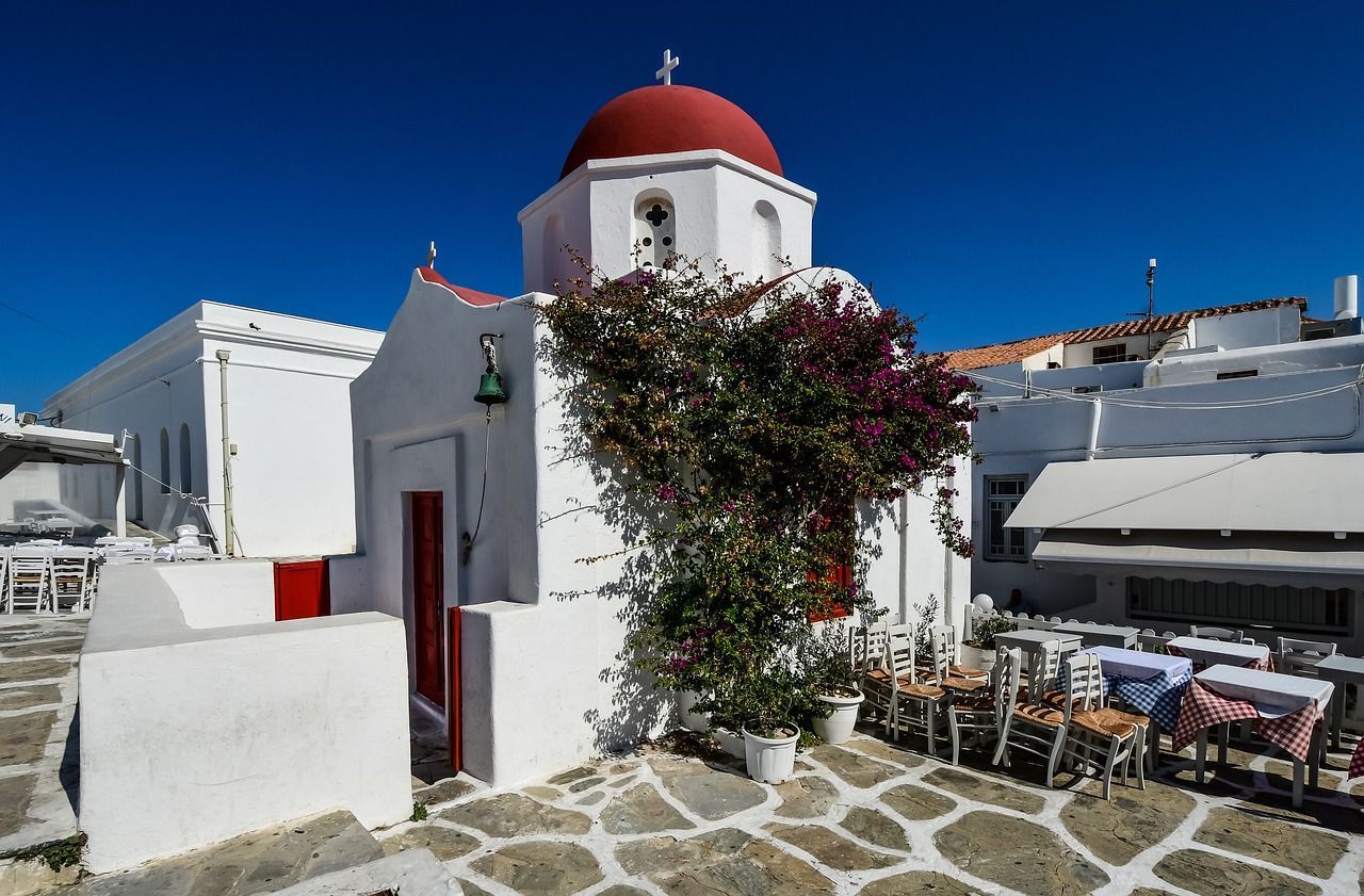 A white building with a red dome on top of it in Mykonos