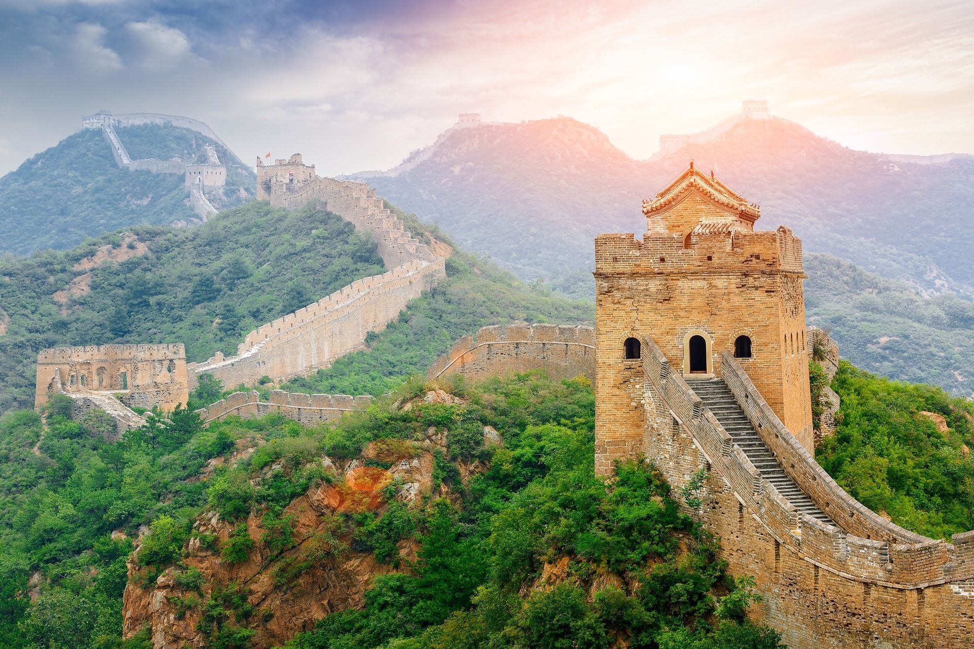 The great wall of china is surrounded by mountains and trees.