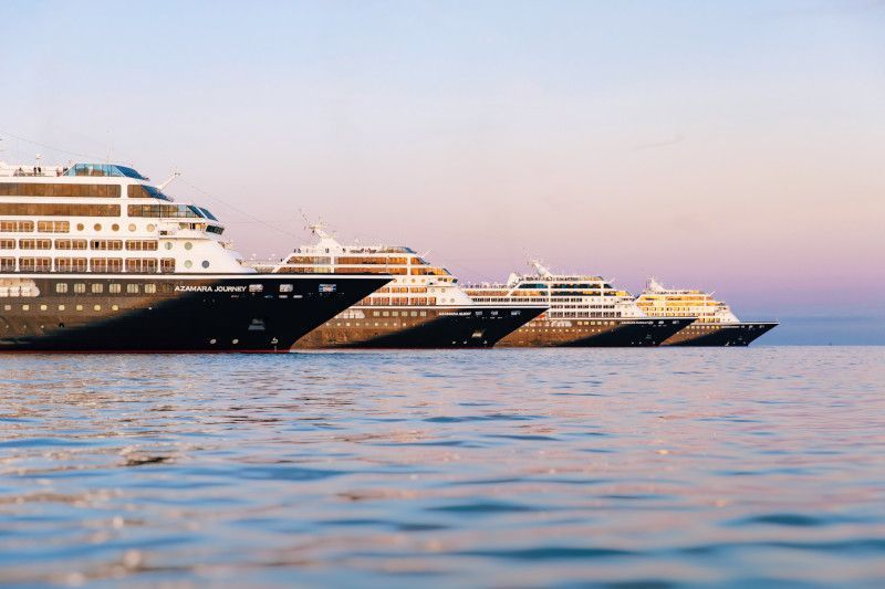 Three cruise ships are lined up in the ocean with Azamara written on them