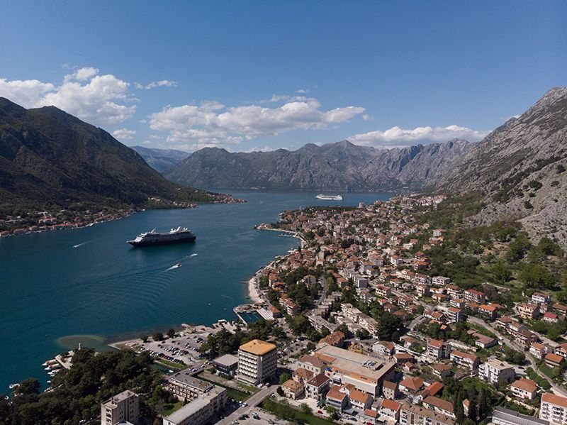 An aerial view of a large body of water surrounded by mountains and a city.