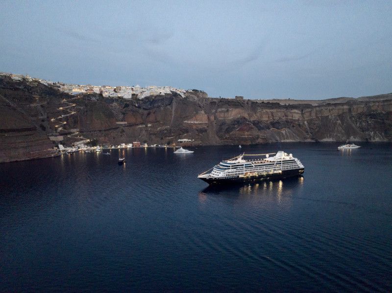 A large cruise ship is in the middle of a body of water with  Azamara written on it