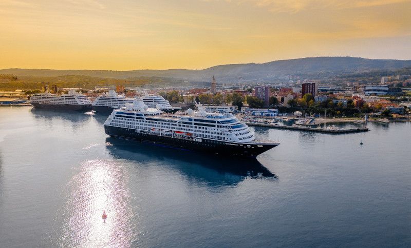 An aerial view of a cruise ship docked in a harbor with Azamara written on it