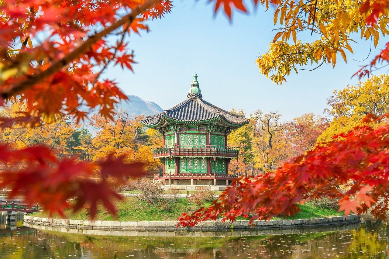 There is a temple in the middle of a lake surrounded by trees with red leaves on Azamara 2027 World Cruise
