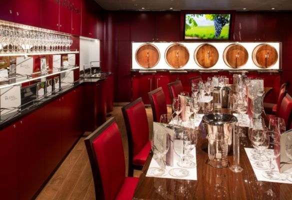 a dining room with a table and chairs and barrels on the wall a BLEND onboard Koningsdam