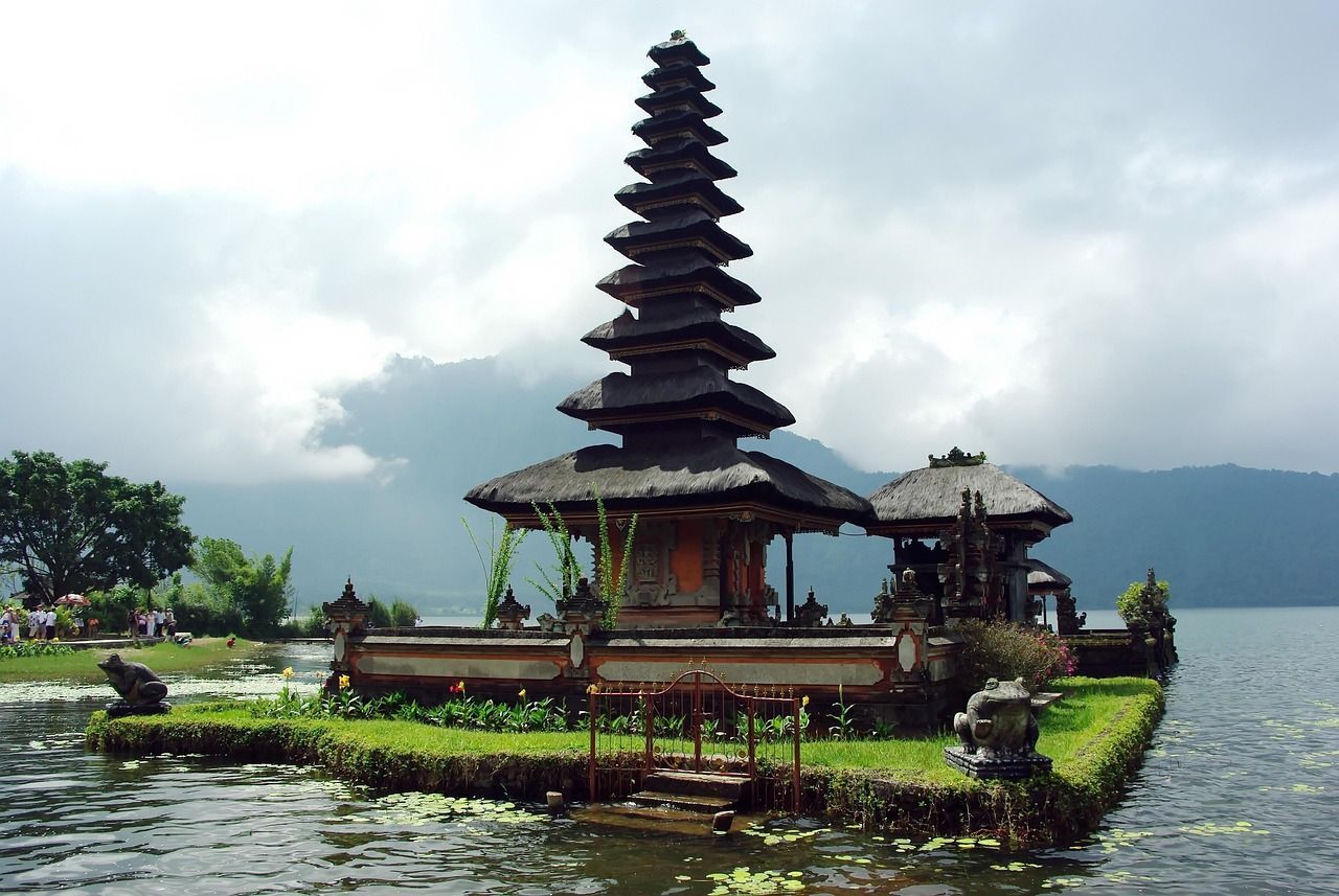 A balinese temple on a small island in the middle of a lake
