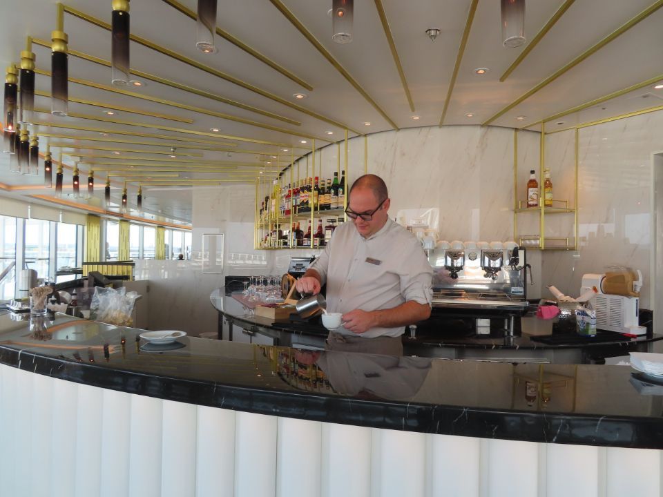 A man is standing behind a counter in a restaurant.