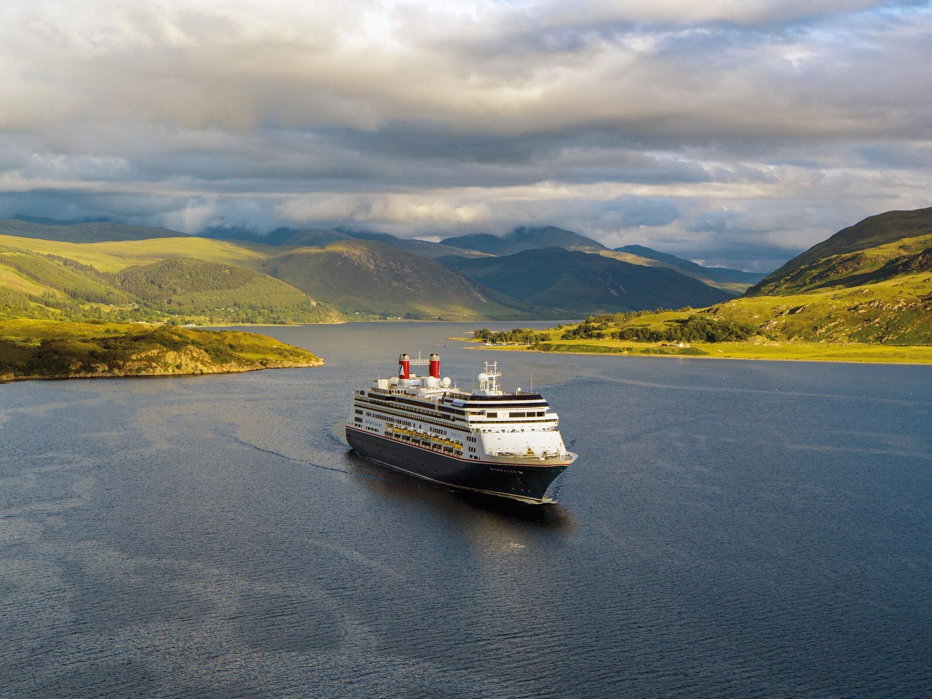 An aerial view of a cruise ship floating on top of a large body of water.