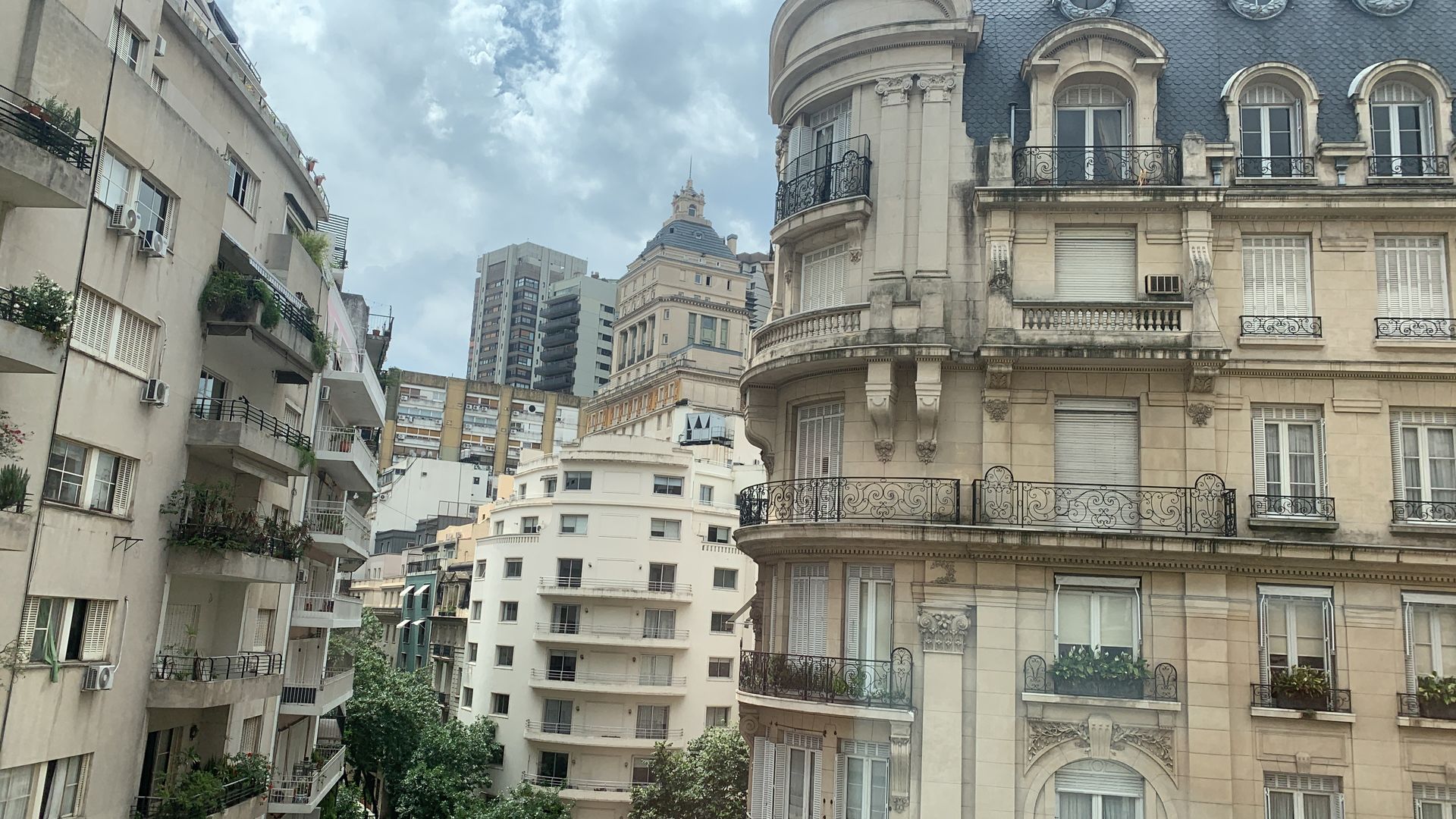 A row of buildings with balconies and a dome in the background in Buenos Aires