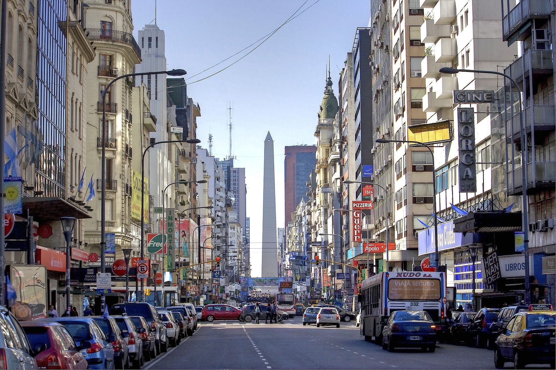 A busy city street with a large obelisk in the background Buenos Aires