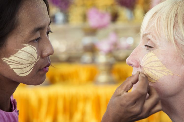 A woman is applying makeup to another woman 's face.