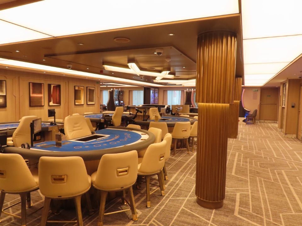 A large room with tables and chairs in a casino.