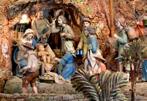 A nativity scene with a baby jesus in a manger surrounded by people.