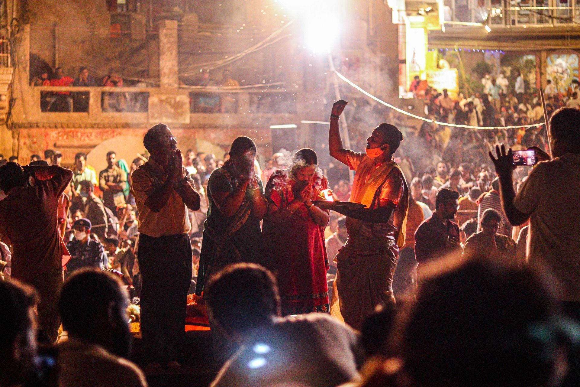 A group of people are standing in front of a crowd of people in Varanasi, India