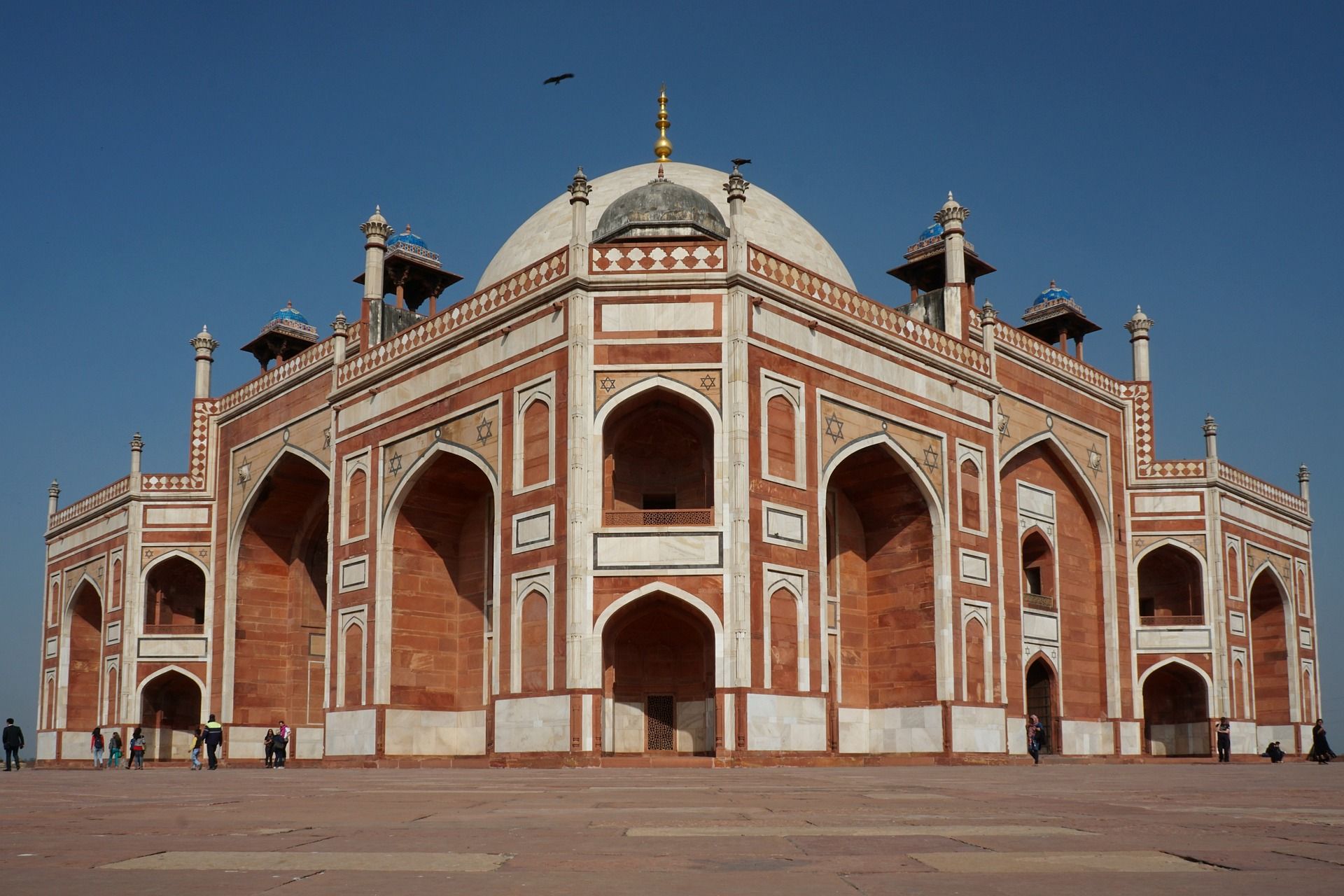 A large brick building with arches and a dome in India