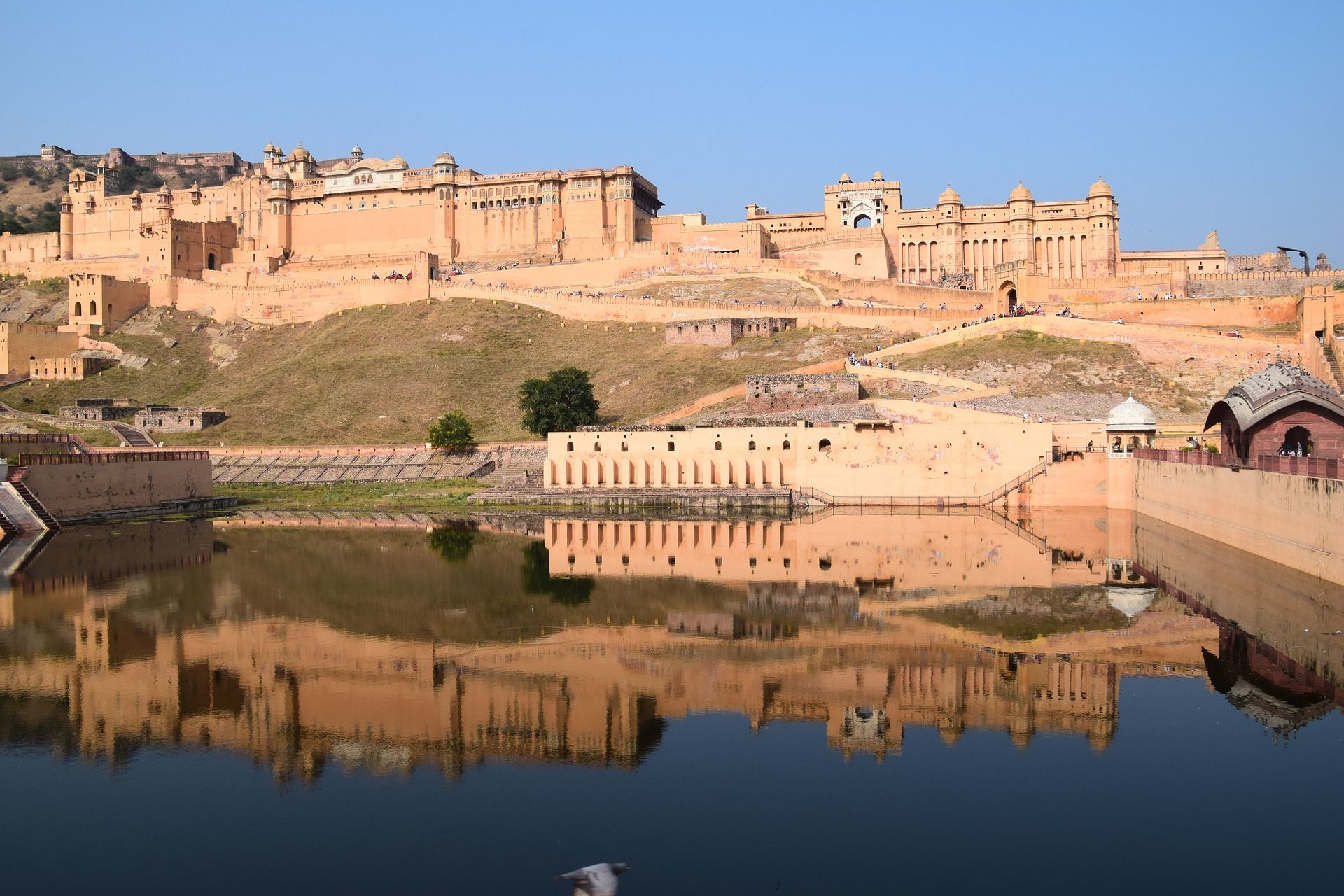 A large building is reflected in a body of water.