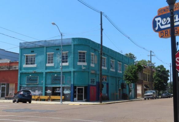 a blue building is on the corner of a city street in Clarksdale, Mississippi