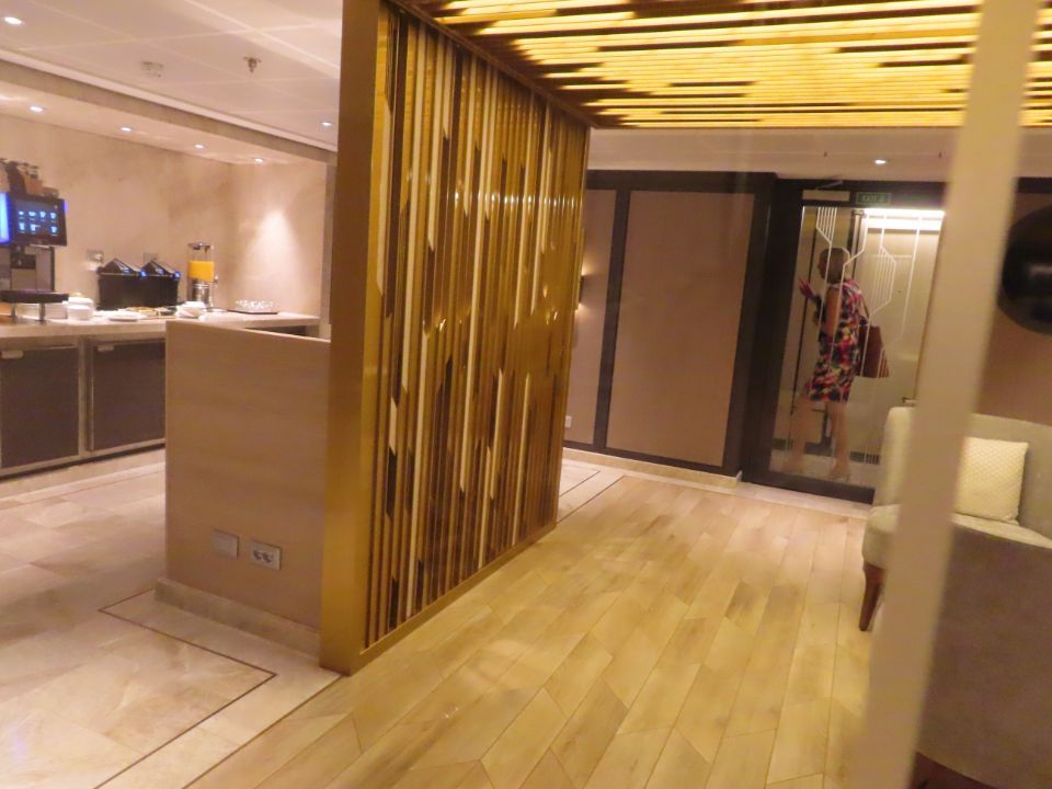 A hallway with a wooden floor and a wooden divider between two rooms.