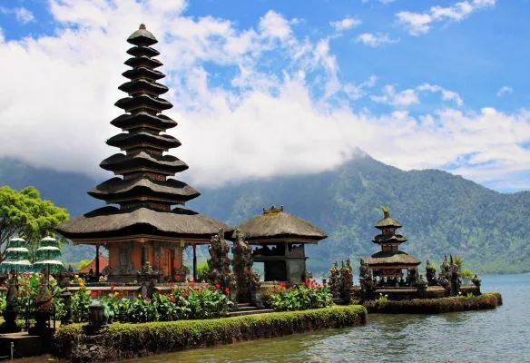 Two temples are sitting on a small island in the middle of a lake in Bali