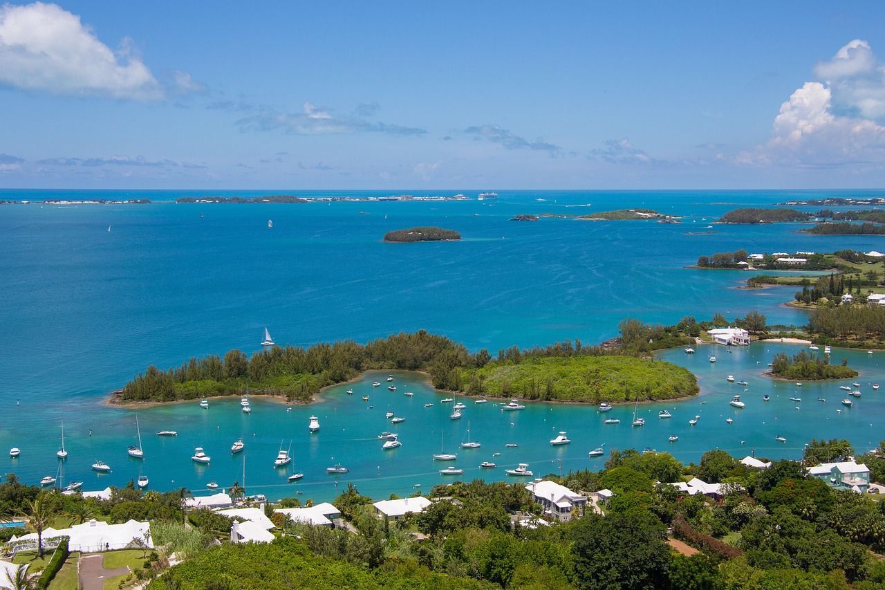 A large body of water with boats in it and a small island in the middle.