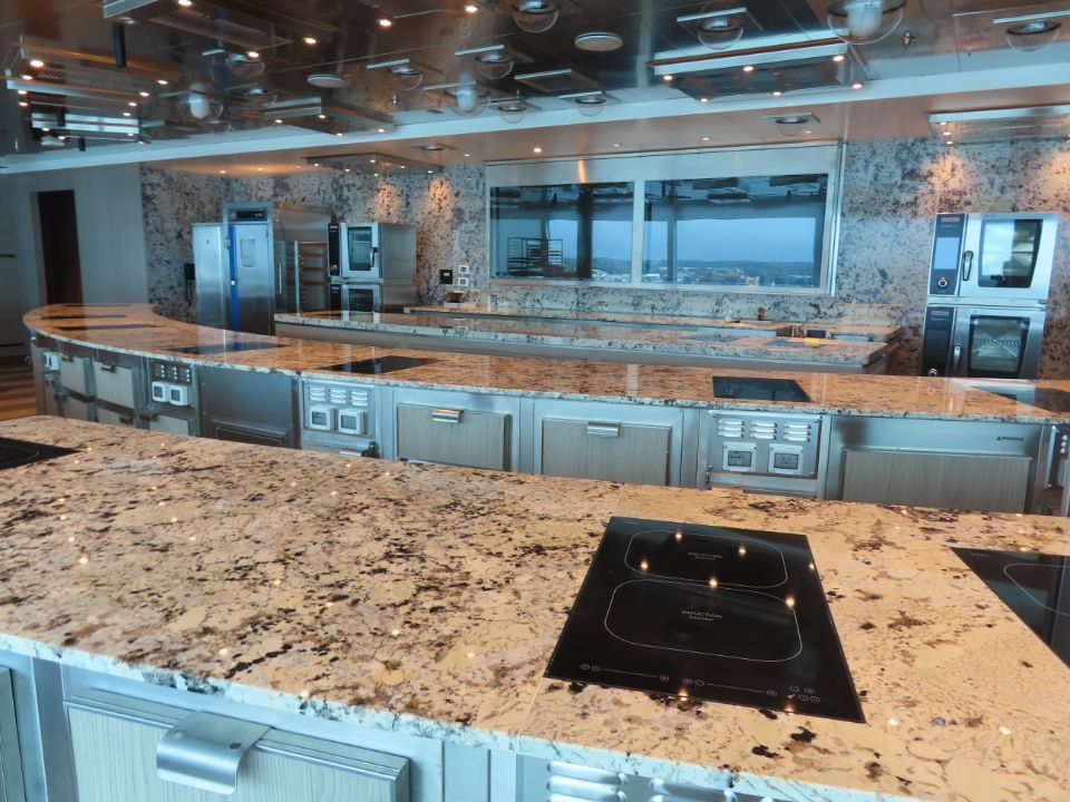 A kitchen with granite counter tops and stainless steel appliances onboard cruise ship Vista