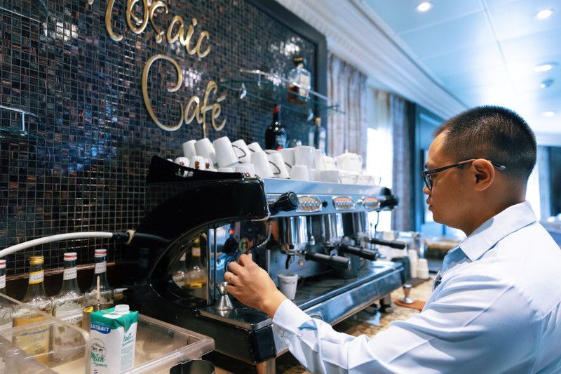 A man is making coffee in a cafe called Mosaic Cafe