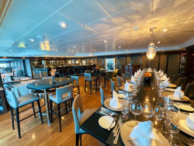 A large dining room with a long table and chairs at Prime C on Azamara