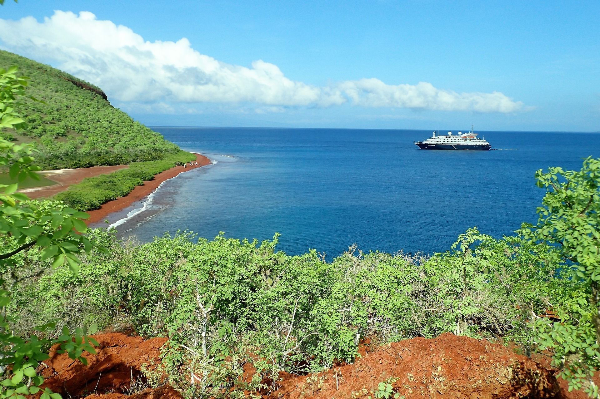 A boat is in the ocean near a small island in the Galapagos, Ecuador