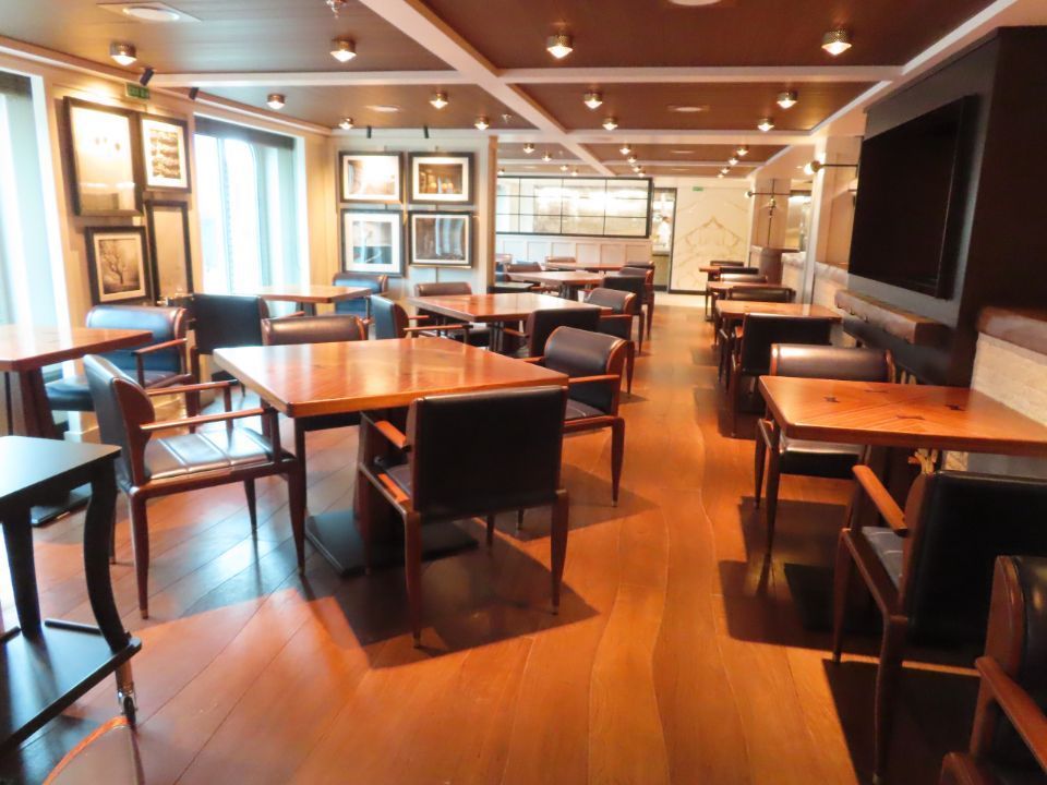 A restaurant with tables and chairs in a large room