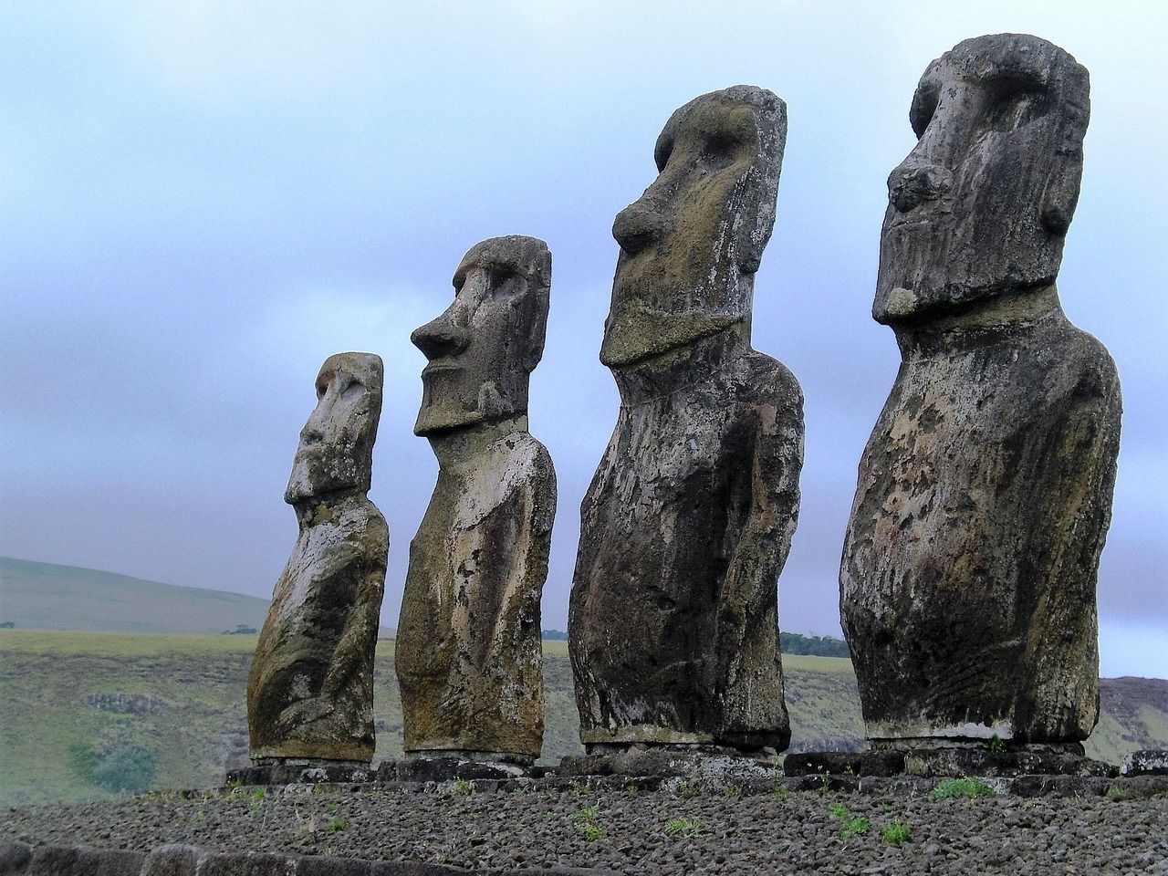 A row of statues are lined up in a field