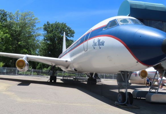 a large passenger jet is parked in a parking lot , The Plane Museum at Graceland